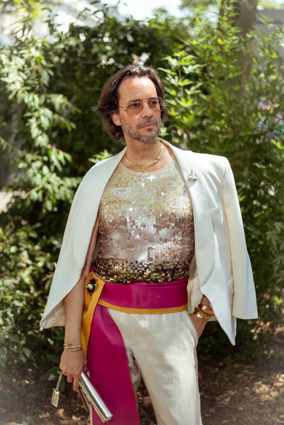 Man in a white blazer, sequined tank and magenta sash, Paris