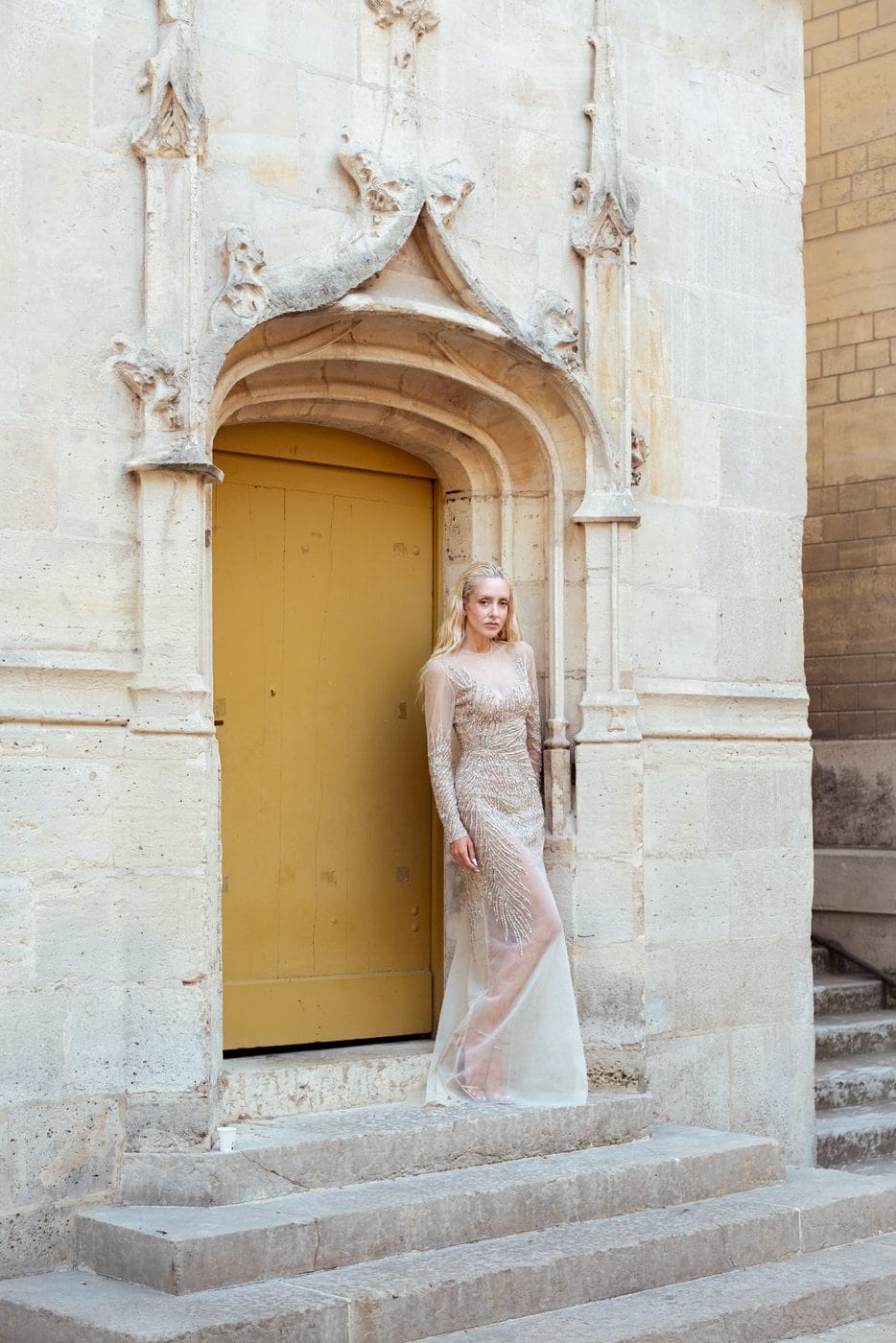 Woman in a pale gown in front of a golden doorway, Sasha Ray (@sasha.ray), Tony Ward Couture