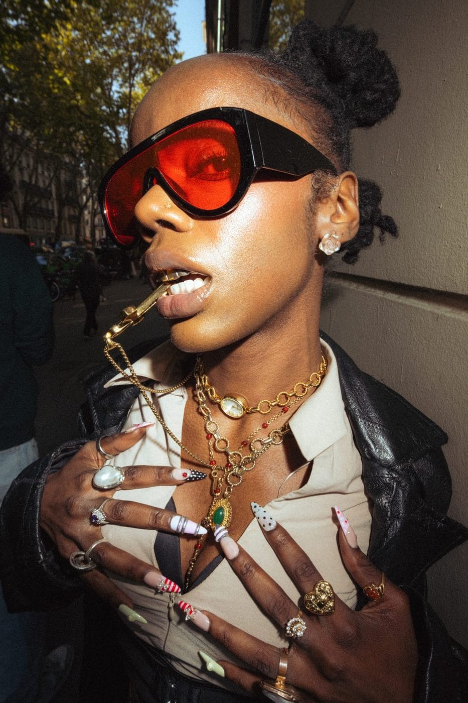 Woman in red wraparound sunglasses with layered gold chains and rings, at night, Shady (@thycallmeshady)