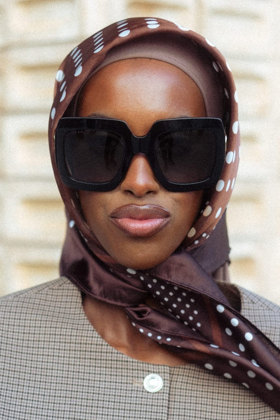 Close-up portrait of a woman in oversized square sunglasses and a brown polka-dot silk headscarf, Hafsa Hasan, Copenhagen Fashion Week
